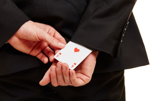 unfair competition concept, businessman pulling ace from sleeve