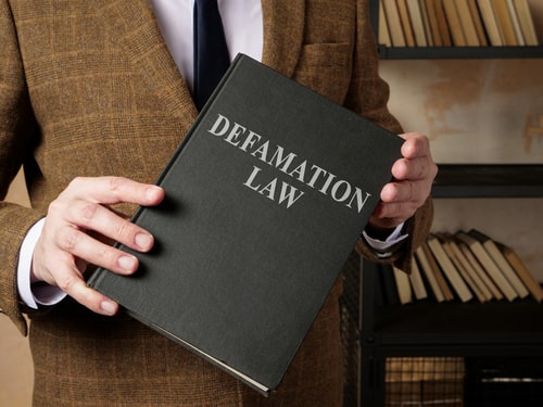 New York business lawyer holding defamation law book