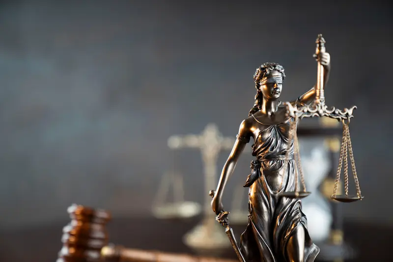 Justice symbols on a table represent business litigation.