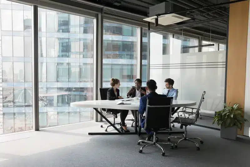 A team meets in a conference room to discuss commercial space for sale.