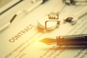 A contract document, pen, and wrenches represent a contract breach by vendors.