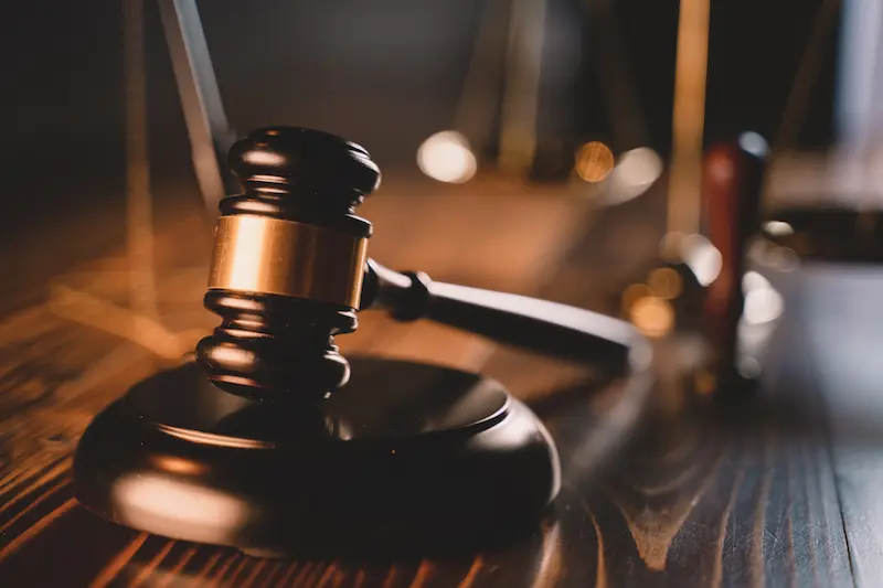 A gavel in a courtroom represents business litigation.