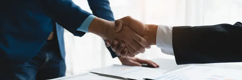 Business handshake after successfully signing legal contract electronically in New York
